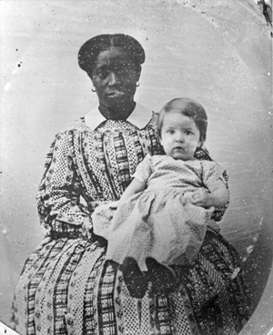 Image of Lucy Cotrell as an adult seated and holding a baby