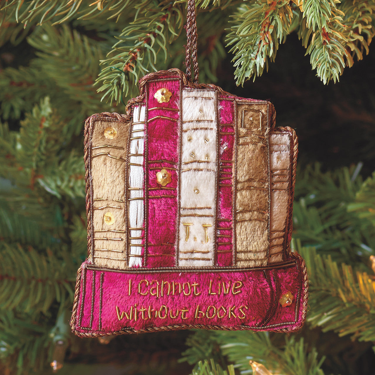 Cloth ornament shaped to look like a row of books and embroidered with different colored fabric and thread