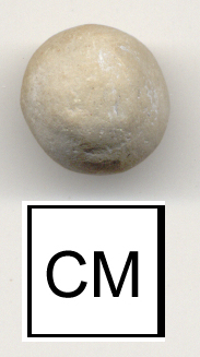 A white, clay marble excavated by archaeologists at Monticello, photographed above a 1cm measurement card