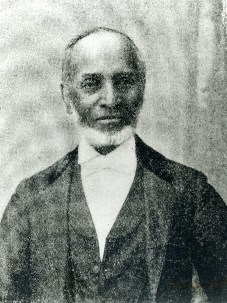 Photo of an elderly Peter Fosset, bearded in black jacket, waistcost, and white shirt 
