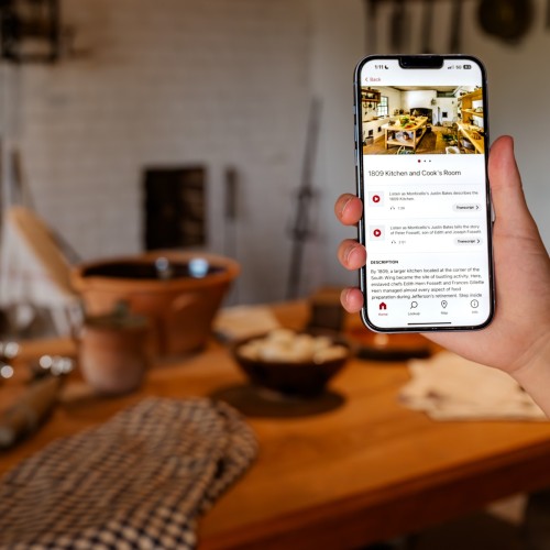 A guest users the Bloomberg Connects app in the South Wing exhibits of Monticello