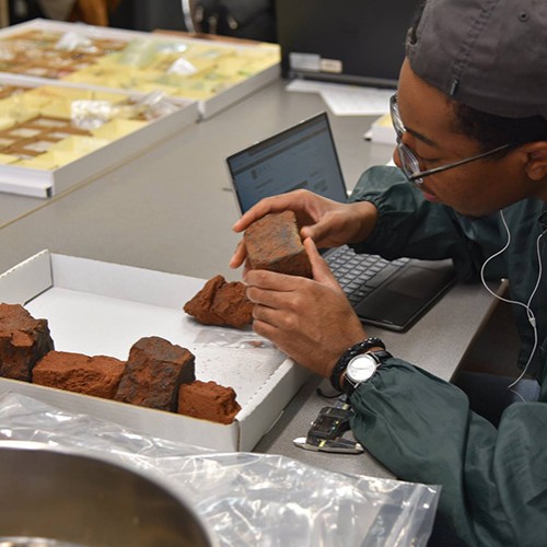 Intern examining brick in Monticello's collections
