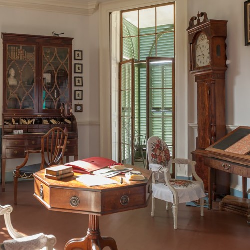 Photo of Monticello's Library with period desks, chairs, and a tall case clock