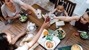 A family toasting over a table of food from the Monticello Café, which serves seasonal menus 