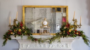 A marble mantle at Monticello decorated with natural, colonial-style Christmas greenery