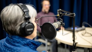 People sitting around a table with headphones and microphones
